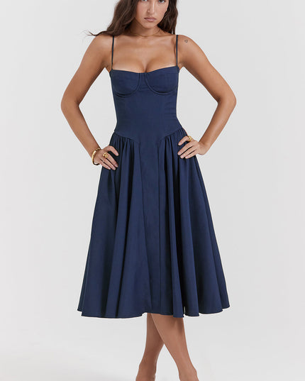 Navy corset midi dress front view with hands on waist, showing structured bodice and pleated skirt