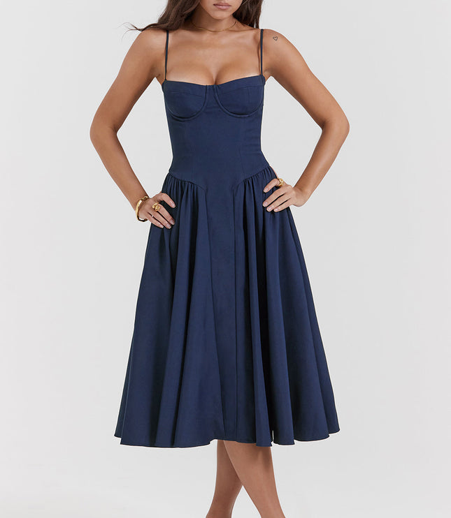 Navy corset midi dress front view with hands on waist, showing structured bodice and pleated skirt