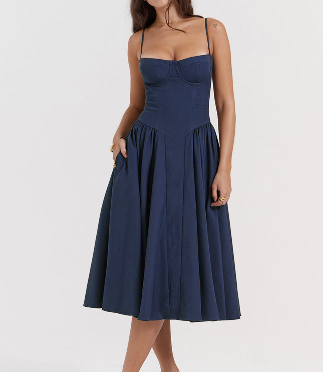 Navy corset midi dress front view with one hand in pocket, showing fitted bodice and gathered skirt