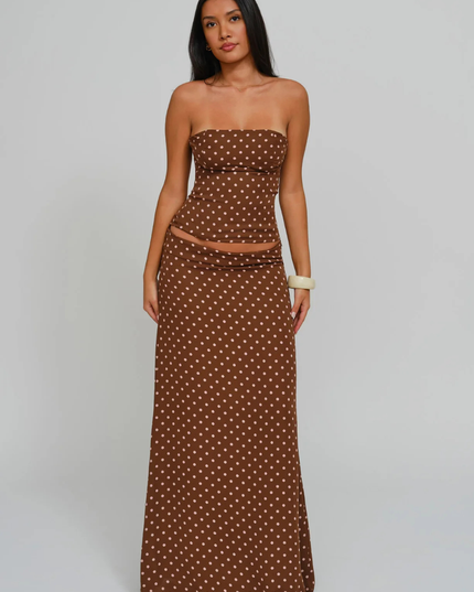 Brown polka dot strapless corset maxi dress with sheer waist panel and long skirt, studio front view