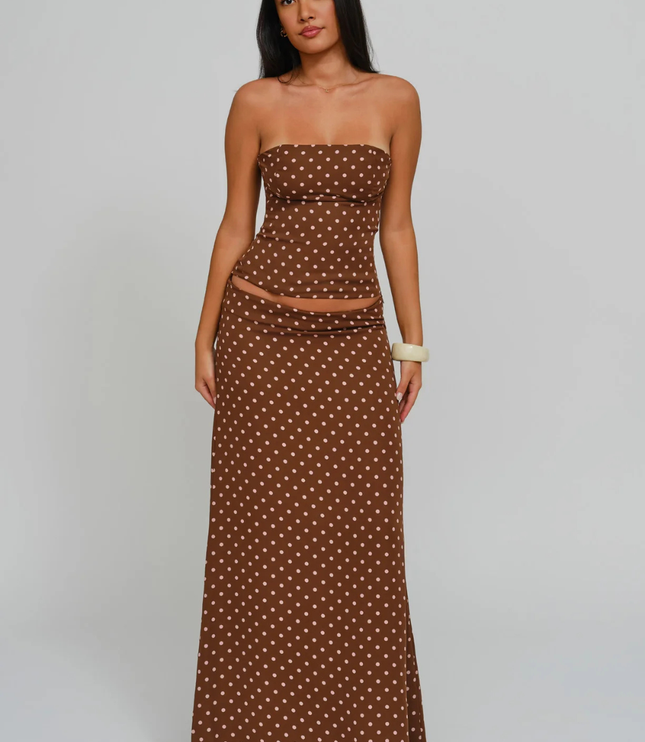 Brown polka dot strapless corset maxi dress with sheer waist panel and long skirt, studio front view