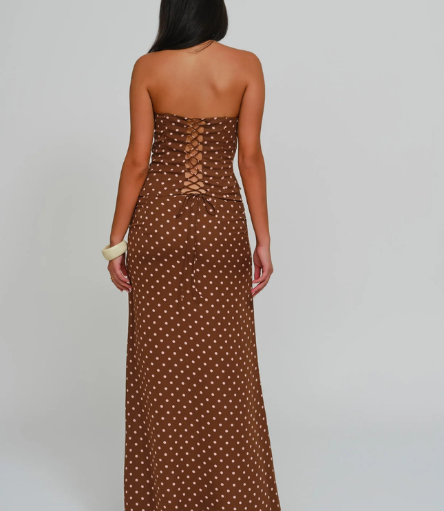 Back view brown polka dot corset maxi dress featuring lace-up back detail and floor-length skirt