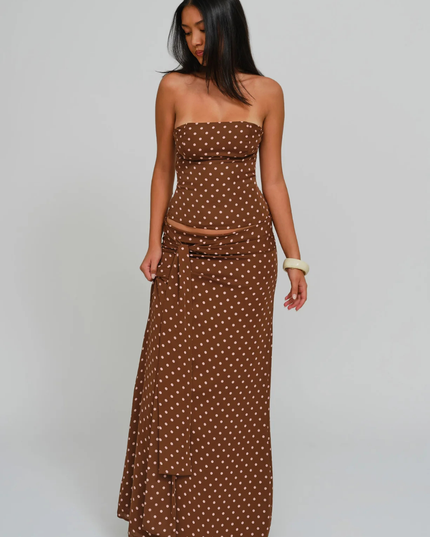 Brown polka dot corset maxi dress with strapless neckline and side sash, angled full length view