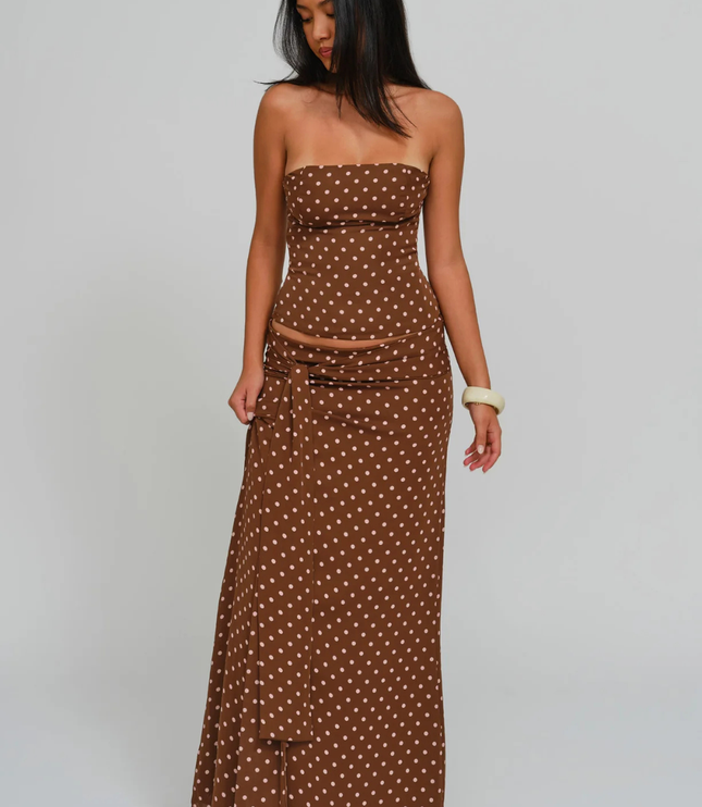 Brown polka dot corset maxi dress with strapless neckline and side sash, angled full length view
