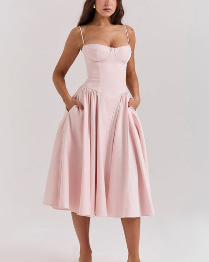 Blush pink corset midi dress front view with hands in pockets, fitted bodice and full skirt