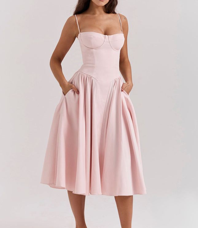 Blush pink corset midi dress front view with hands in pockets, fitted bodice and full skirt