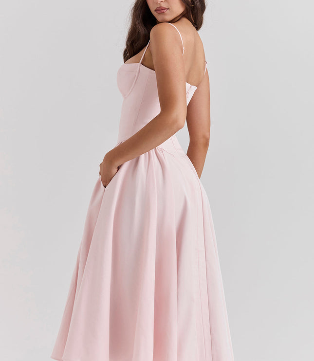 Side view of blush pink corset midi dress showing fitted waist, thin straps, and flared skirt