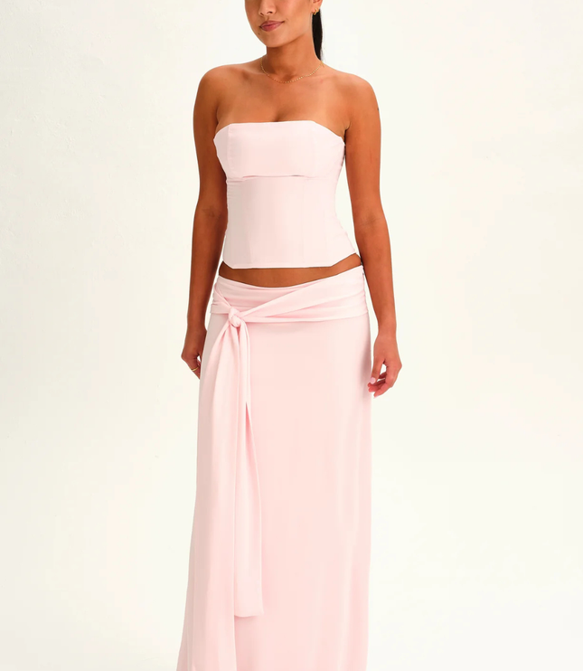 Blush pink strapless corset maxi dress with high waist and front tie sash, full length front view