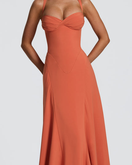 Detail view of coral pleated maxi dress showing ruched bust and smooth fitted waist panel