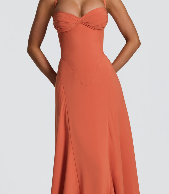 Detail view of coral pleated maxi dress showing ruched bust and smooth fitted waist panel