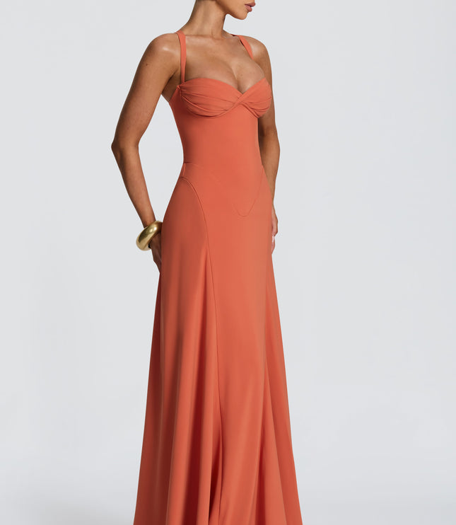Side view of coral pleated maxi dress with sweetheart neckline, fitted waist and flowy skirt