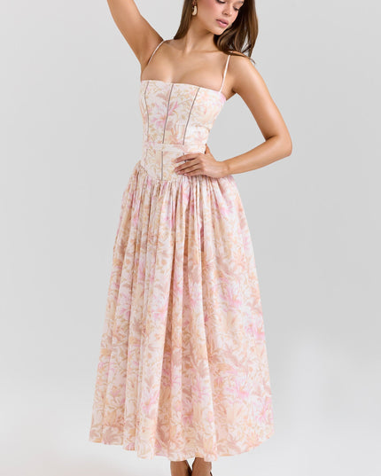 Side pose of blush floral corset midi dress highlighting fitted bodice and gathered skirt