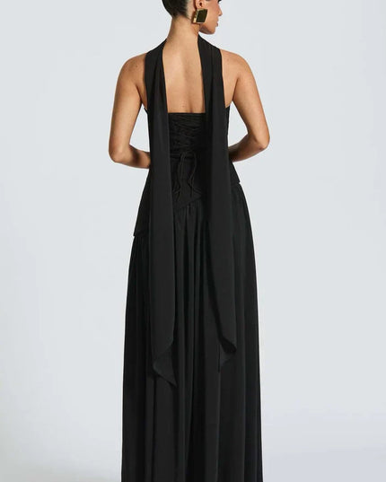 Back view of black halter maxi dress with open back, lace-up detail, and long drape
