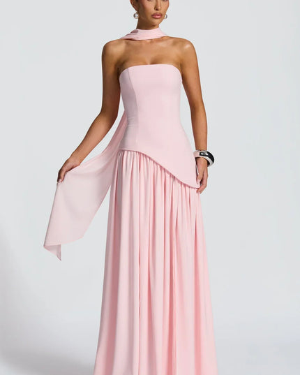 Back view of pink halter maxi dress with flowing skirt, fitted back, and soft scarf detail