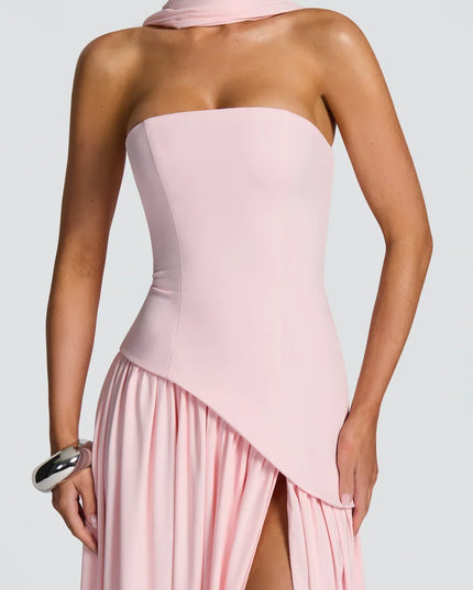 Close-up of pink strapless halter maxi dress with asymmetrical overlay and slit