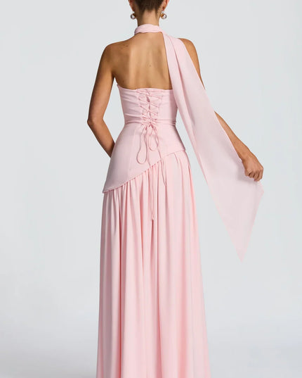 Back view of pink halter maxi dress with lace-up back, scarf tie, and long skirt