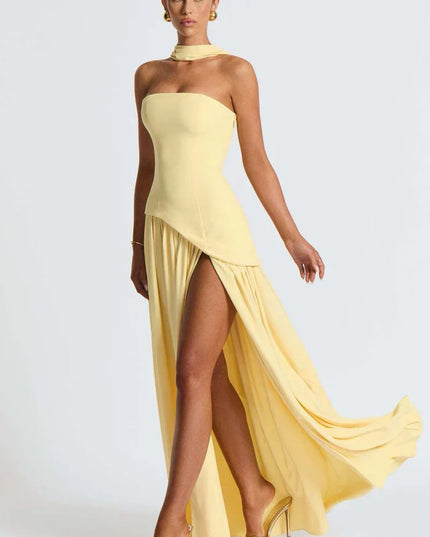 Pale yellow halter maxi dress with asymmetrical overlay, high slit, and flowing skirt front angle