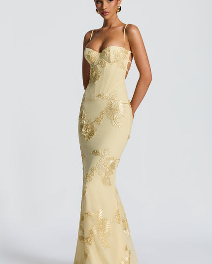 Butter yellow lace maxi dress with floral appliqué and sweetheart bustier bodice, angled front view
