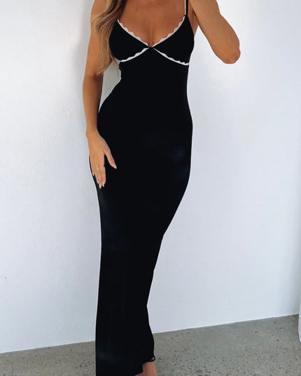 Black lace trim maxi dress with adjustable straps, fitted silhouette, and white lace detail on bust, paired with black heels.