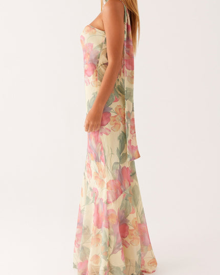 Side profile of a women's floral strapless maxi dress, showcasing the elegant asymmetrical design and attached neck scarf.