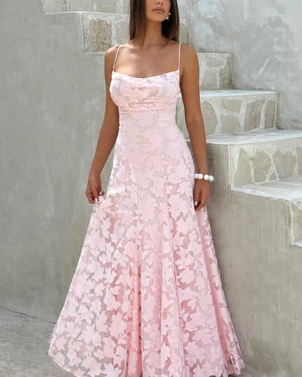 Full-length women's pink floral jacquard maxi dress with delicate spaghetti straps and a flowing skirt, for a special occasion.