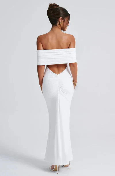 Back view of a white off-shoulder maxi dress, with a stylish ruched back and a graceful V-neckline.
