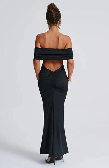 Back view of a black off-shoulder maxi dress, showcasing the ruched back detail and elegant V-shaped cut-out.
