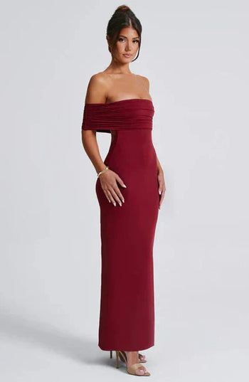 Side profile of a burgundy off-shoulder maxi dress, highlighting the fitted design and elegant floor-length skirt.
