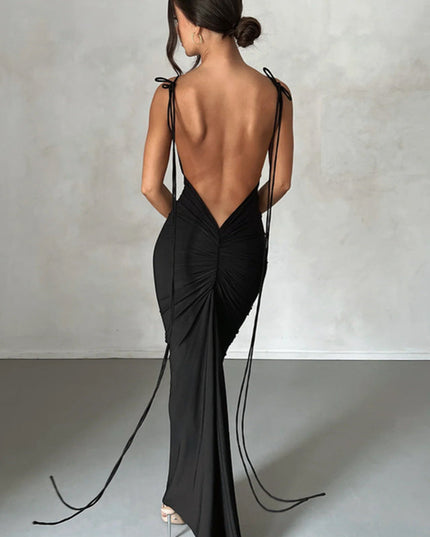 Back view of a women's black pleated plunge neck backless maxi dress with long tie details