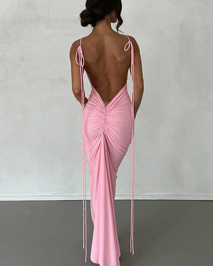 Back view of a women's pink pleated plunge neck backless maxi dress with adjustable tie straps