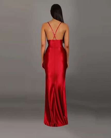 Back view of a red formal backless V-neck maxi dress, featuring delicate criss-cross straps and a floor-length skirt.