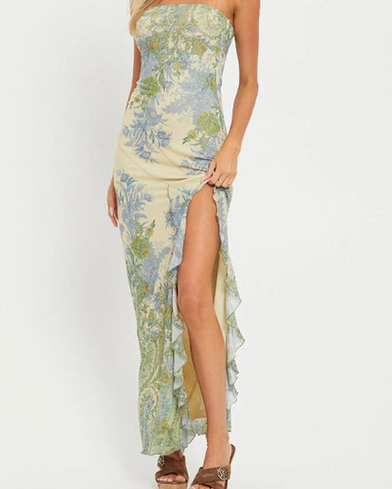 Full-length view of a women's strapless paisley print maxi dress in light yellow with blue and green patterns, featuring a high leg slit with ruffles.