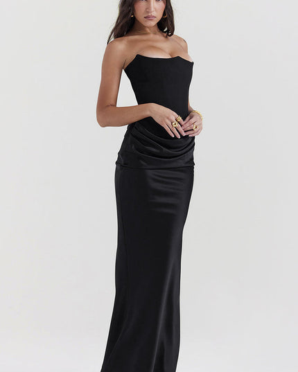 Side profile of a woman in a black off-shoulder bustier maxi dress, highlighting the fitted silhouette.