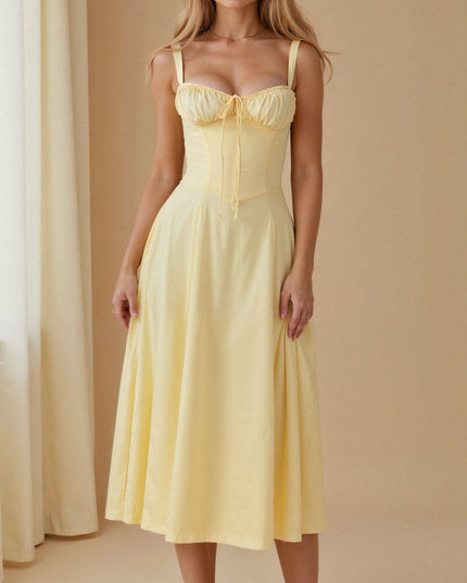 Front view of a light yellow summer midi dress with a bow-front corset top and flowing skirt.