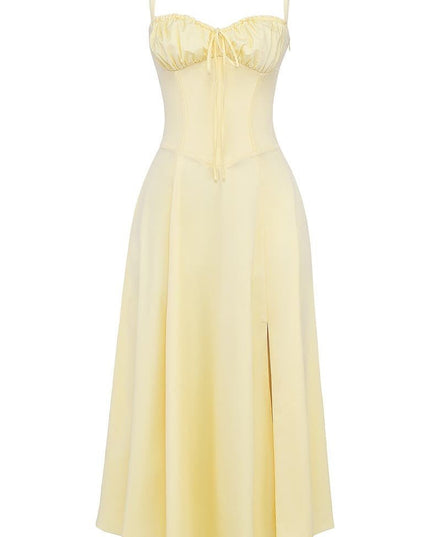 Light yellow summer corset midi dress featuring a ruched bow front bodice, thin straps, and a flowing skirt with a slit.