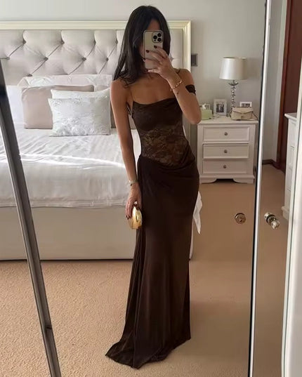 Full-length view of a woman wearing a brown off-shoulder lace corset maxi dress, holding a gold clutch.