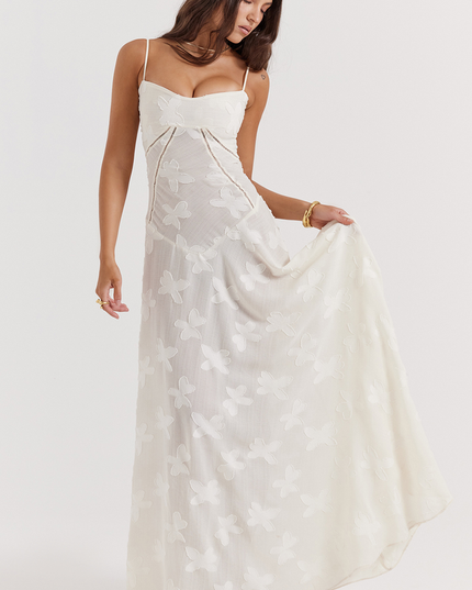 Front view of a white floral corset maxi dress with a sweetheart neckline, thin straps, and a full skirt with butterfly- floral details.