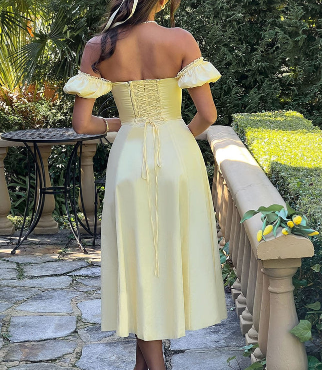Back view of a light yellow off-shoulder corset midi dress with puff sleeves and lace-up detailing, worn with white heels.