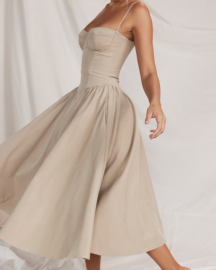 Side view of a women's light beige sweetheart neck corset midi dress, showcasing the gathered waist and movement of the skirt.