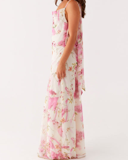 Side profile of a women's white floral maxi dress with pink and green pattern, showing the flowing fabric.