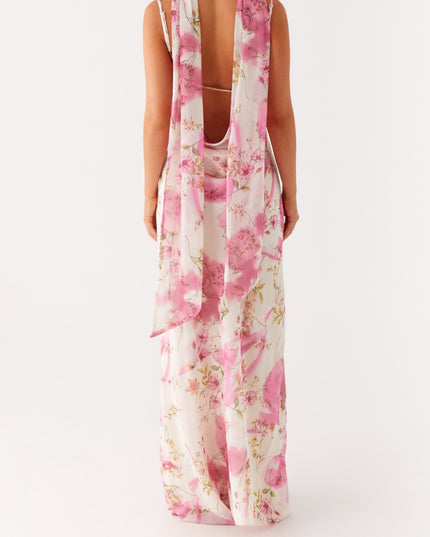 Back view of a women's white floral maxi dress with open back and long pink floral ties.