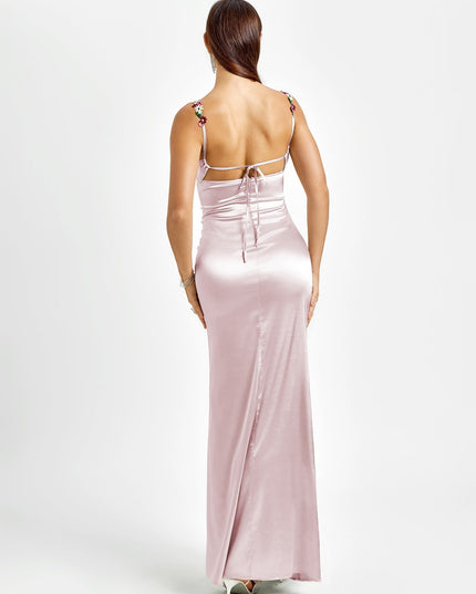 Back view of a light pink formal maxi dress with floral embroidered straps and an open back with tie details.