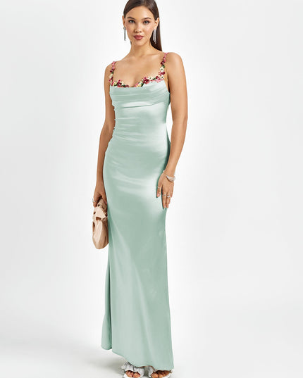 Elegant light mint green satin maxi dress with floral cowl neck, thin straps, and a small matching clutch.