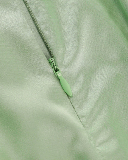 Close-up of the light green zipper detail on the side of a satin cowl neck mini romper.