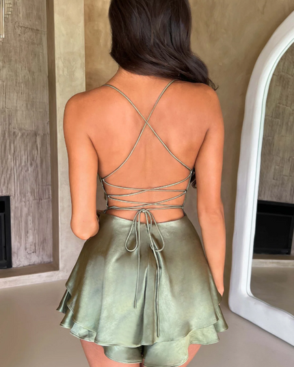 Rear view of a women's olive green satin backless mini romper, highlighting the intricate lace-up back design.