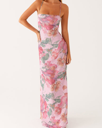 Front view of a women's pink floral square neck maxi dress with hands on hips, showing full length.