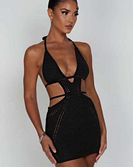 Side profile of the black crochet plunge halter neck mini dress, showing the mini length and textured knit fabric.