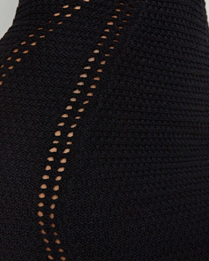 Close-up detail of the black crochet mini dress showing intricate open-knit patterns on the side.