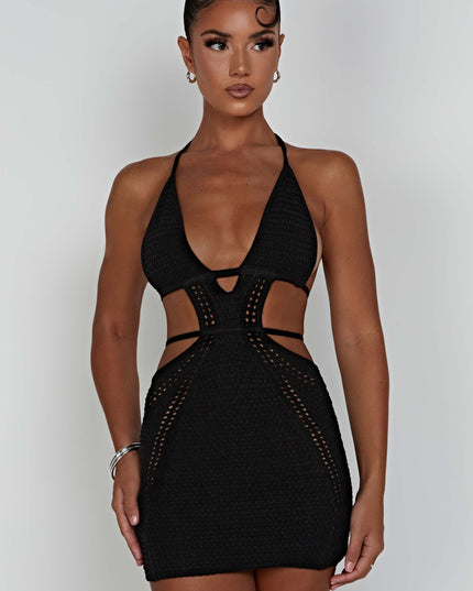 Three-quarter view of the black crochet plunge halter neck mini dress, emphasizing the form-fitting silhouette and cut-outs.