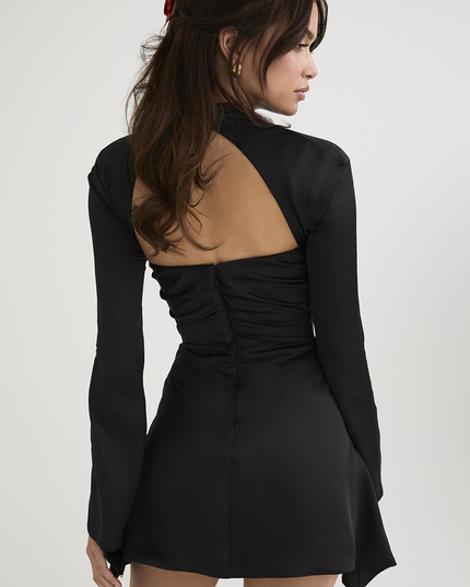 Rear view of the black halter cut out long sleeve mini dress, showing the open back and zipper closure.